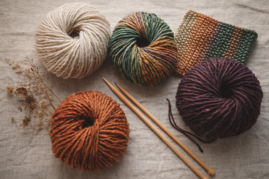 Photo à plat de pelotes de laine et d'aiguilles à tricoter — burda STRICKEN 03/2026 : neuf modèles avec Lang Yarns