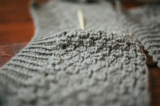 person holding gray knit textile